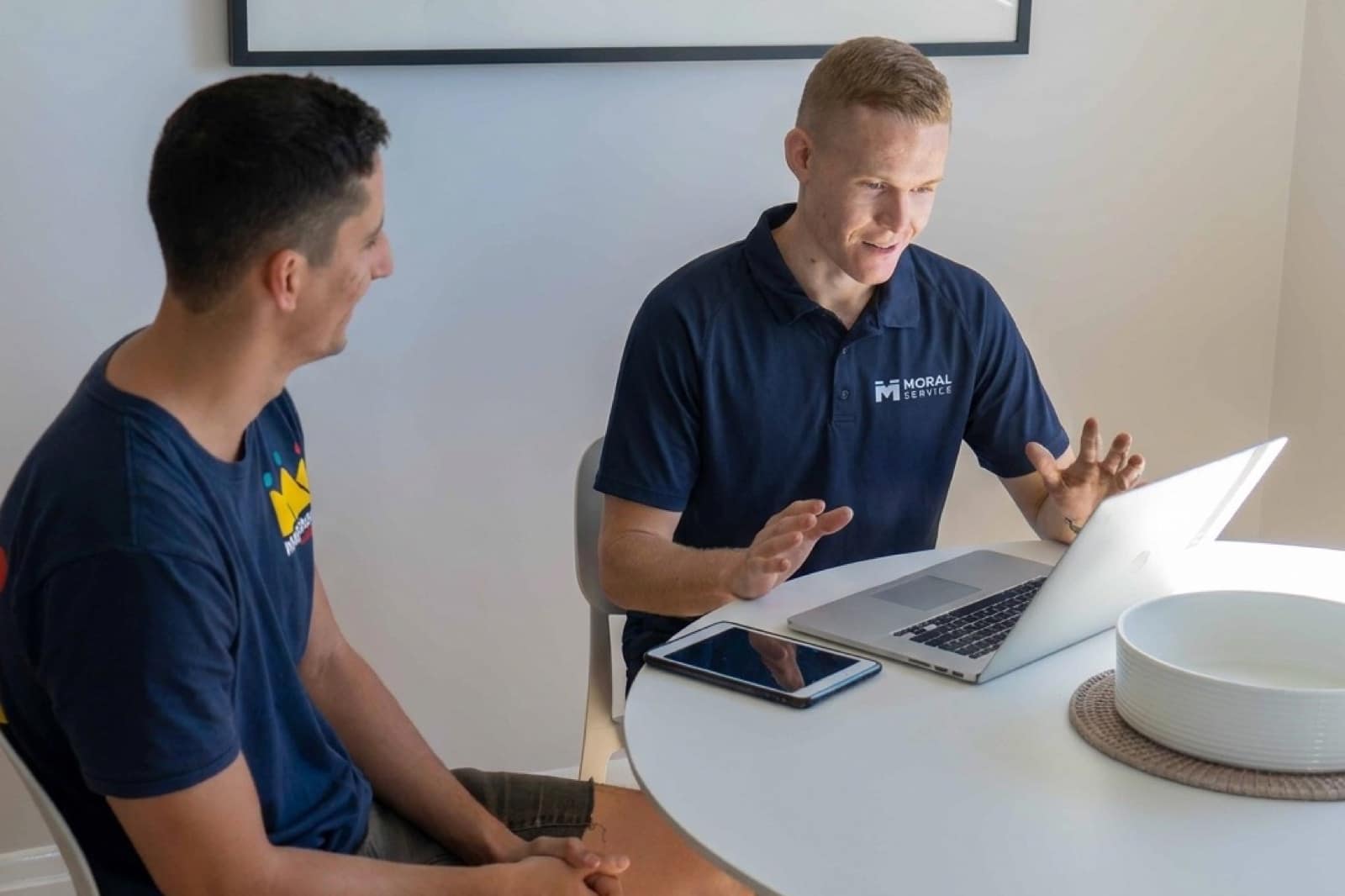Shaun from Moral Service running a Gold Coast homeowner through the job on the laptop at the kitchen table