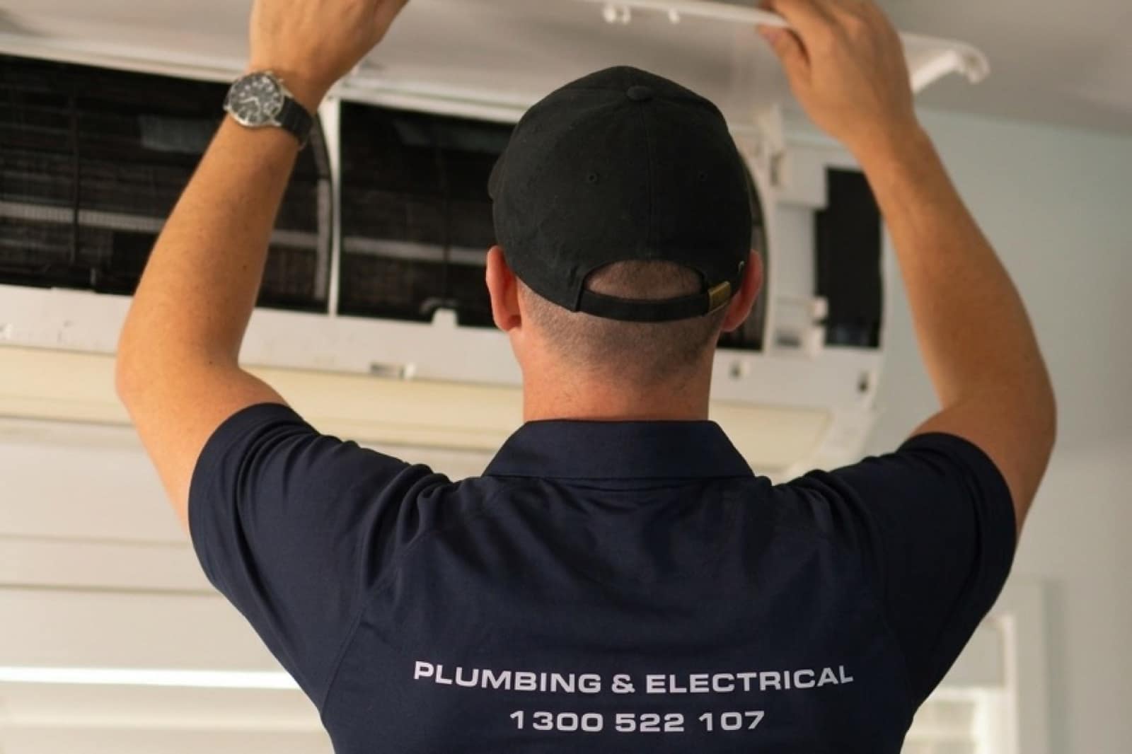 A Moral Service electrician servicing a split-system air conditioner indoor unit