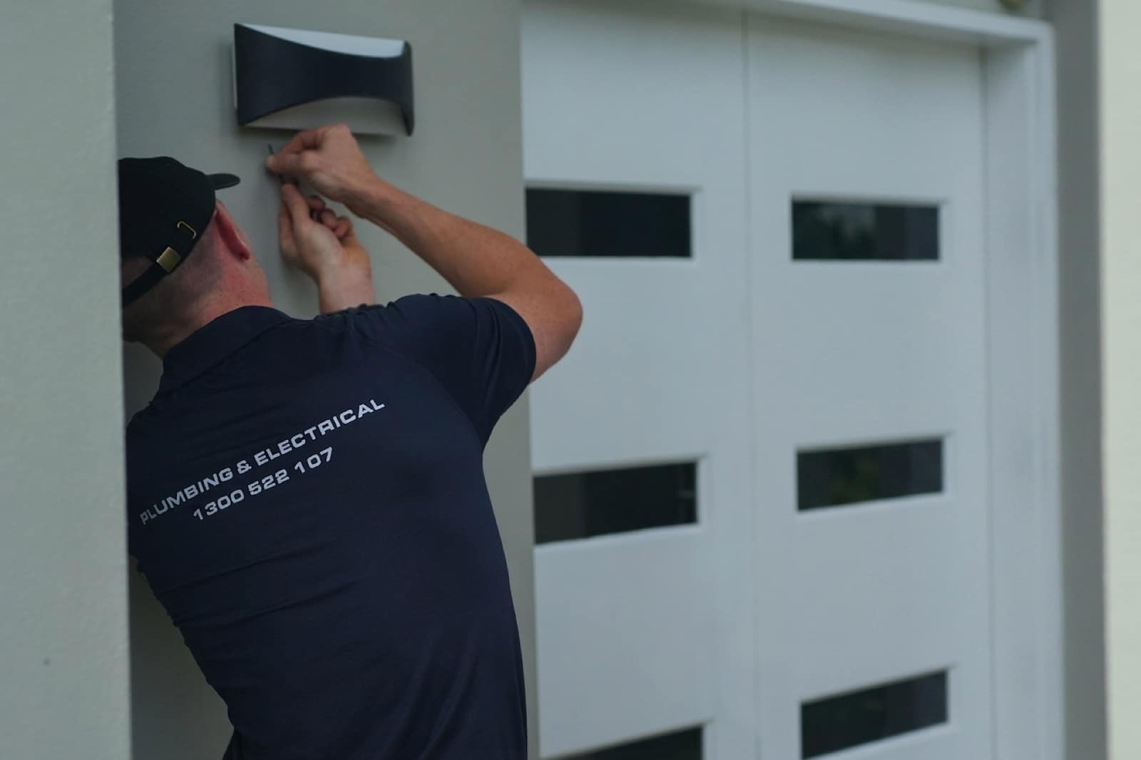 A Moral Service electrician fitting off a kitchen rangehood in a new kitchen