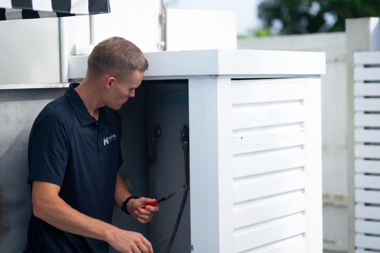 An outdoor hot water system being repaired at a Gold Coast home
